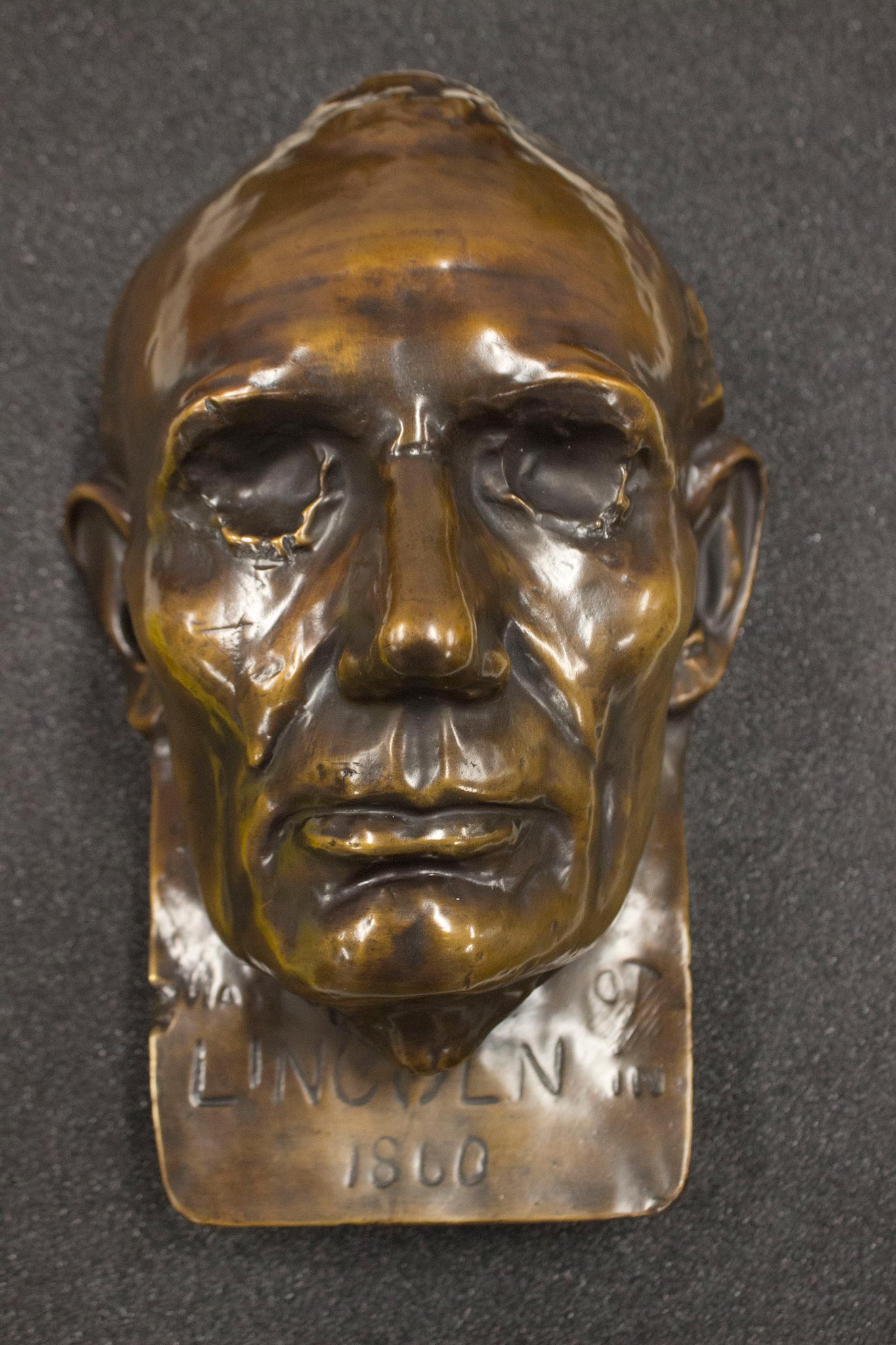 This is a bronze replica of the beardless life mask of Abraham Lincoln created by sculptor Leonard Volk in 1860. He created casts of Lincoln’s hand as well. Volk used the face mask to create full busts of Lincoln, and other sculptors and artists have used this mask for their own work.